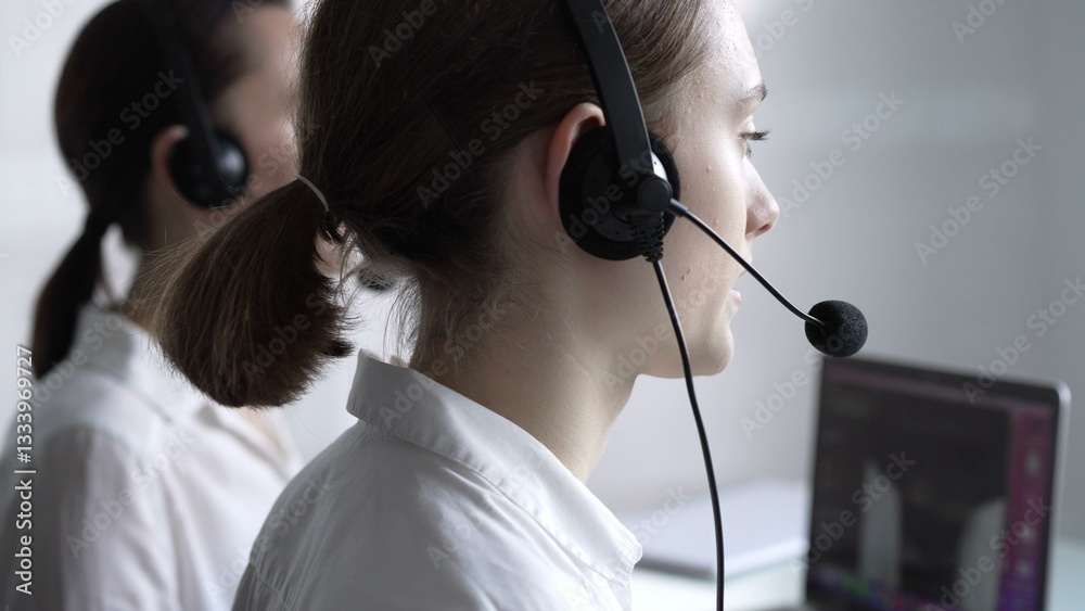Young female call center operator in white blouse is assisting clients online, providing customer support and answering inquiries. Business call center