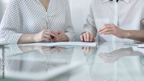 Obraz na płótnie Business colleagues reviewing a contract, engaging in negotiations and strategic decision making in modern glass office, white casual dress style. Businesspeople concept w salonie