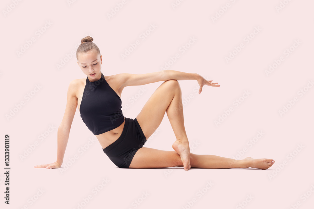 Obraz premium Young woman doing artistic gymnastics training, flexible rhythmic gymnast performing poses and showing skills and talent, sport workout, fitness and Well-Being concept, isolated on pink background