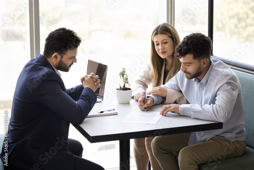 Couple agreed on contract terms and conditions, signing legal document, finalize negotiations process successfully with financial advisor or real-estate agent, buy property or getting bank mortgage