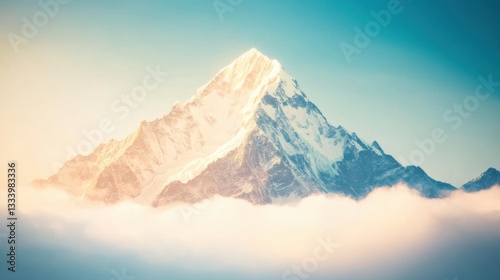 Snow-covered mountain towering over soft clouds welcomes the dawn light, creating a stunning visual contrast in the sky