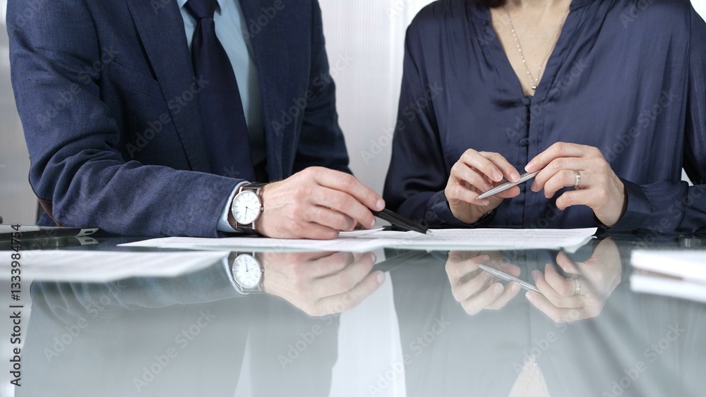 Business people reviewing contract terms during a meeting, negotiating and making decisions together. Business people concept, close up