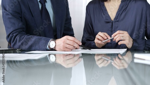 Obraz na płótnie Business people reviewing contract terms during a meeting, negotiating and making decisions together. Business people concept, close up w salonie