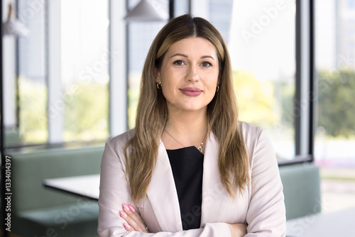 Smiling business woman look at camera with positive, optimistic expression, enjoy corporate mission success, exuding self-assurance, professionalism and competence, take break, relaxing at workplace