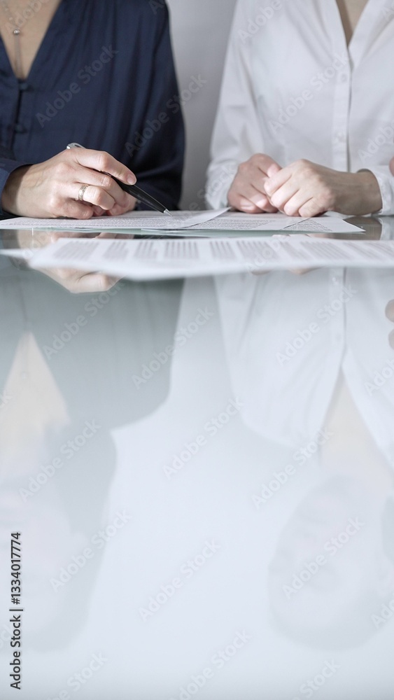 Business people are reviewing contract terms during a meeting, negotiating and making decisions together, vertical close up view. Copy space area