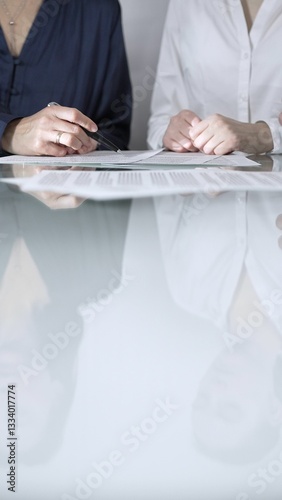 Obraz na płótnie Business people are reviewing contract terms during a meeting, negotiating and making decisions together, vertical close up view. Copy space area w salonie