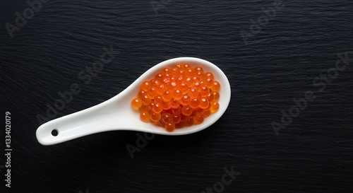 Delicious orange salmon roe in white spoon on black background red top food dish life view rich tasty