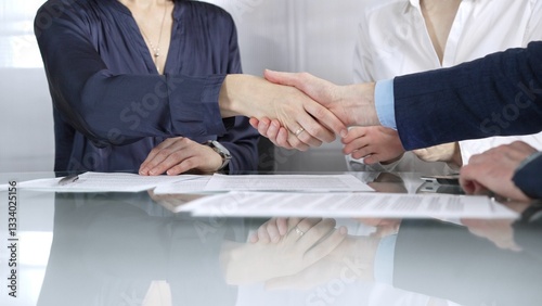 Obraz na płótnie Unrecognizable business partners shaking hands after signing contract at glass table in office meeting, making a deal and closing agreement, close up of handshake w salonie