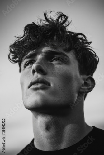 A black and white portrait of a person with curly hair, suitable for use in editorial or creative contexts