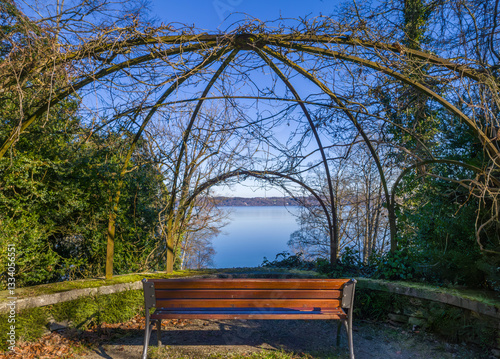 Leere Parkbank an einem Aussichtspunkt am Starnberger See, blauer Himmel im Winter, Alpenvorland, Bayern, Deutschland, Europa