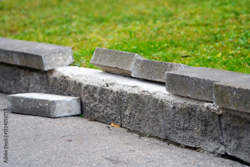 Obraz na płótnie Damaged concrete curb with broken and displaced bricks on city sidewalk, signs of wear, erosion, need for urgent repair in urban infrastructure. Displaced bricks on worn concrete curb. Selective focus w salonie