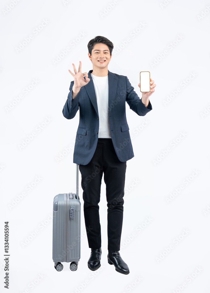 Full body image of young asian businessman pulling suitcase and using phone on white background Full body image of young asian businessman pulling suitcase and using phone on white background