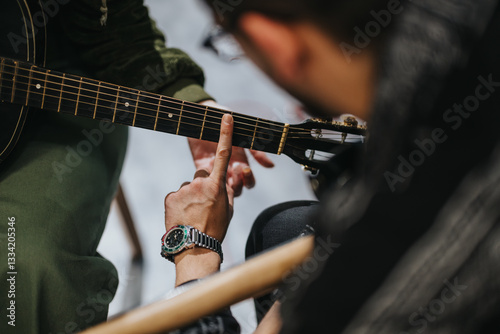 Music lesson focusing on guitar playing technique with an instructor and student