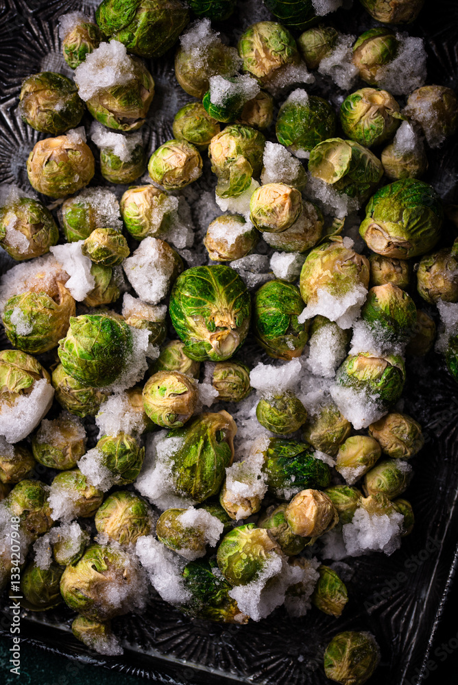 Fototapeta premium Frozen Brussels sprouts on dark background