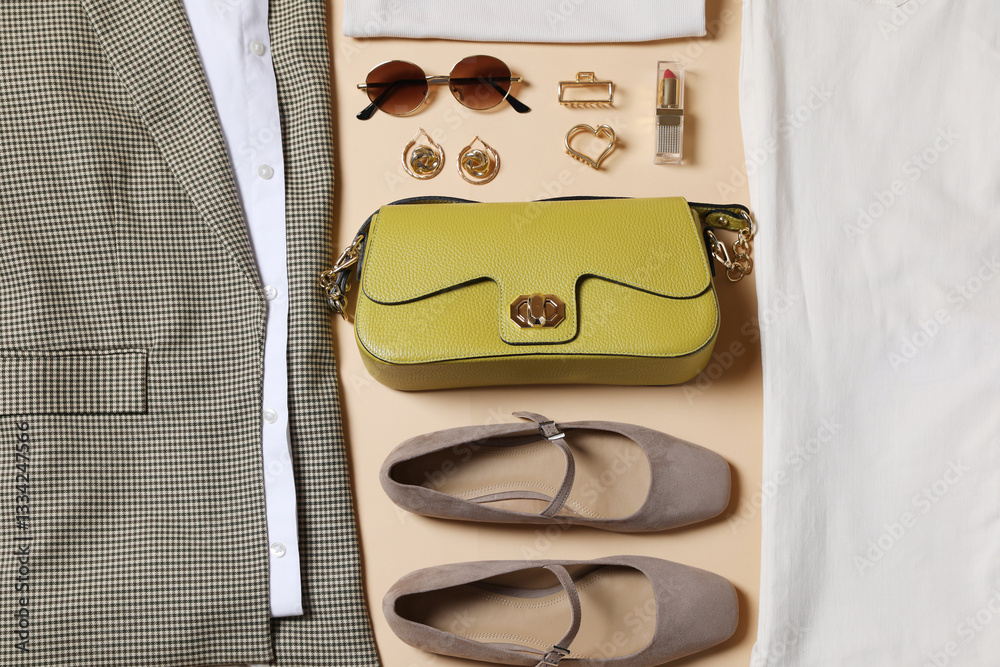 Fototapeta premium Elegant women's outfit. Stylish clothes and accessories on beige background, above view