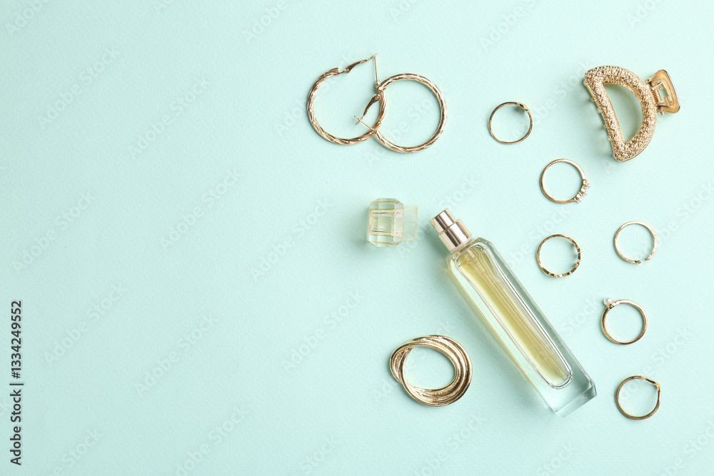 Fototapeta premium Stylish accessories and perfume on light blue background, flat lay. Space for text