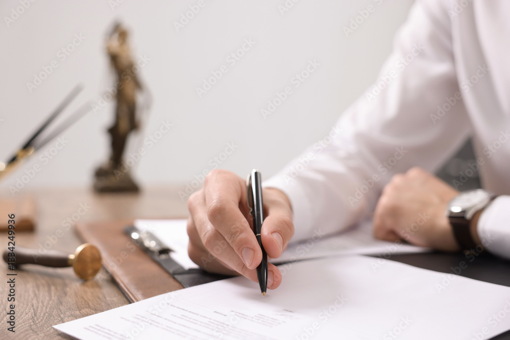 Notary signing document at table in office, closeup Notary signing document at table in office, closeup