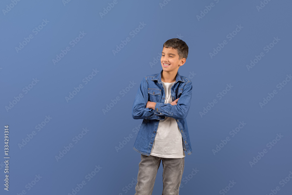 Confident smiling male entrepreneur with arms crossed looking away contemplating over blue background Confident smiling male entrepreneur with arms crossed looking away contemplating over blue background