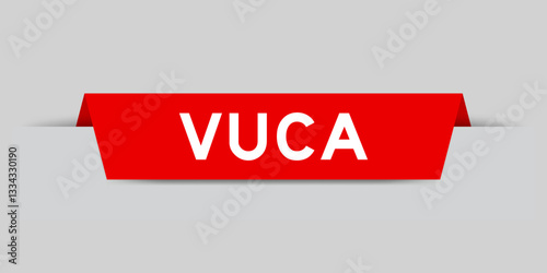 Red color inserted label with word VUCA (abbreviation of Volatility, uncertainty, complexity and ambiguity) on gray background