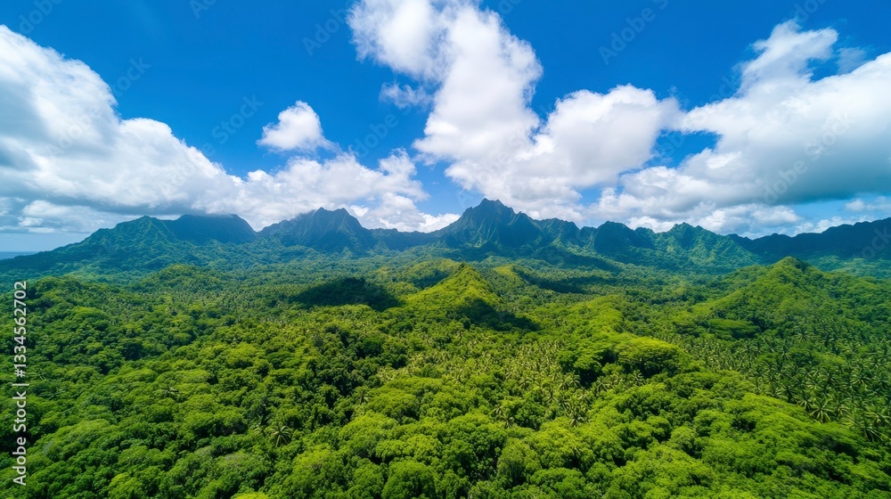Obraz premium Lush Green Tropical Landscape with Mountainous Backdrop and Blue Sky and White Clouds