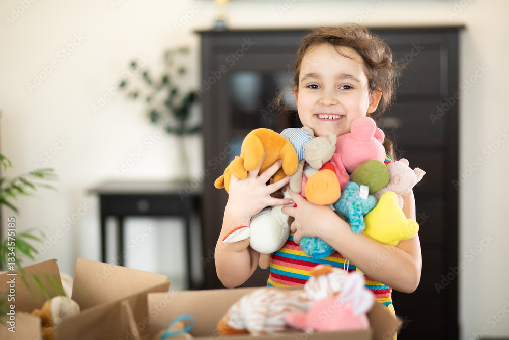 Happy cute little kid girl having fun after moving into a new home. Child with cardboard boxes with toys. Happy cute little kid girl having fun after moving into a new home. Child with cardboard boxes with toys.
