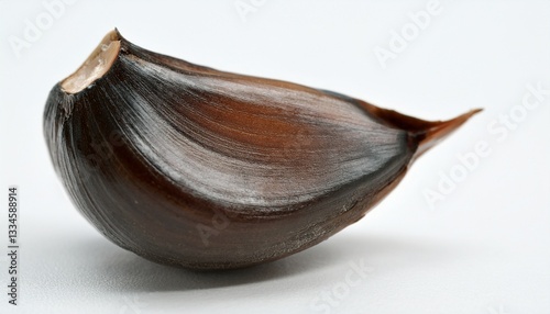 Wallpaper Mural Black Garlic Clove Close-up: A single, richly colored clove of black garlic, showcasing its unique texture and distinct ridges, offers a glimpse of the culinary world's hidden gems. Torontodigital.ca