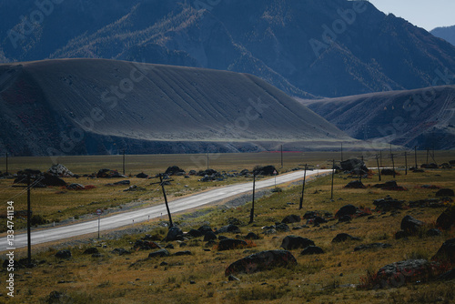 Obraz na płótnie A winding road cutting through the majestic mountains of the Altai Republic, surrounded by breathtaking natural beauty. w salonie