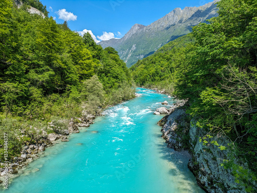 Soca Valley, Slovenia – Aerial view of the emerald-green Alpine River Soca on a bright sunny summer day with green foliage..The last wild river in Europe in Triglav National Park near the Vricic Pass