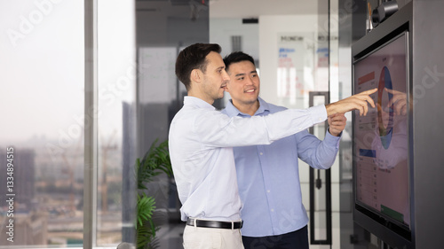 Photos Successful young multiethnic businessmen reviewing project analytics on presenta