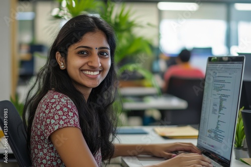 Cheerful and successful indian woman programmer at work inside modern office, tech support worker with laptop typing on keyboard smiling