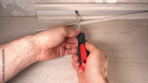 installing the baseboard with a screwdriver and self-tapping screws
