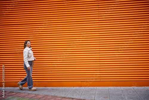 Wallpaper Mural Woman walking on orange background Torontodigital.ca