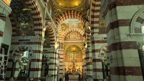 Richly decorated interior of Marseille’s Notre-Dame de la Garde Basilica, featuring detailed mosaics, marble arches, intricate religious art, and vibrant colors historic Catholic architecture