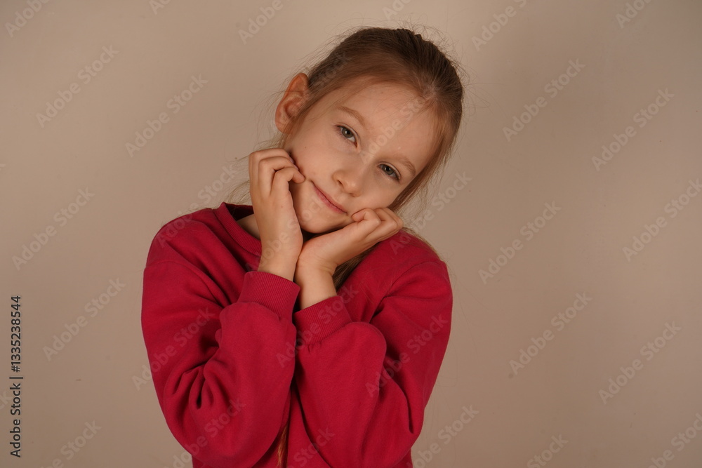 Her gentle facial expression exudes calm and sweetness. A picture-perfect moment of innocence. The little girl rests both hands on her chin, striking a thoughtful pose for the camera. Her gentle facial expression exudes calm and sweetness. A picture-perfect moment of innocence. The little girl rests both hands on her chin, striking a thoughtful pose for the camera.