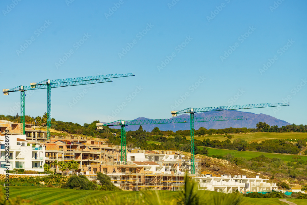 Spanish coast view with construction site with crane industrial equipment