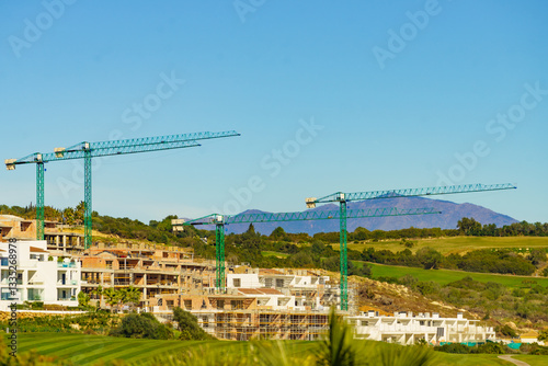 Obraz na płótnie Spanish coast view with construction site with crane industrial equipment w salonie