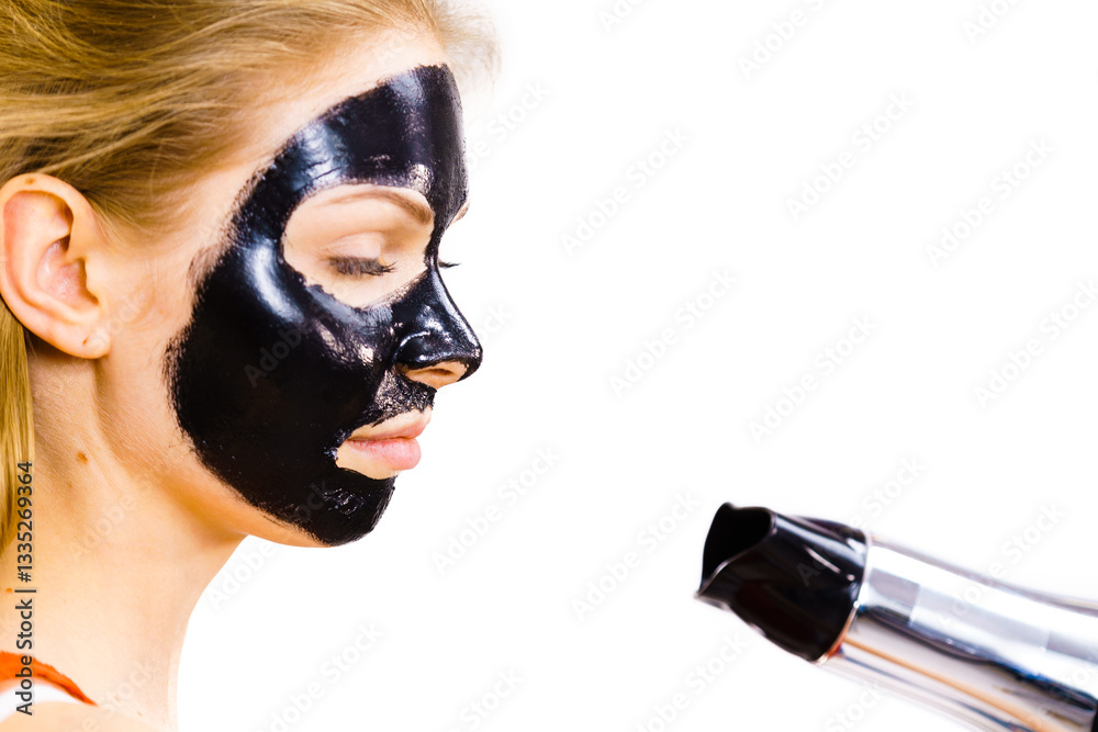 Girl drying peel-off black mask on face