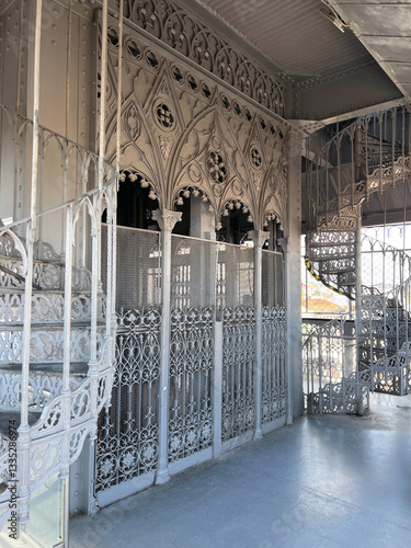 Intricate ironwork and spiral staircases surrounding an antique elevator photo