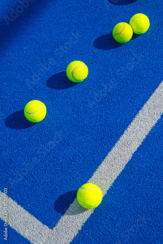 Fototapeta Naklejka Na Ścianę i Meble -  blue paddle tennis court with three balls, racket sport concept background