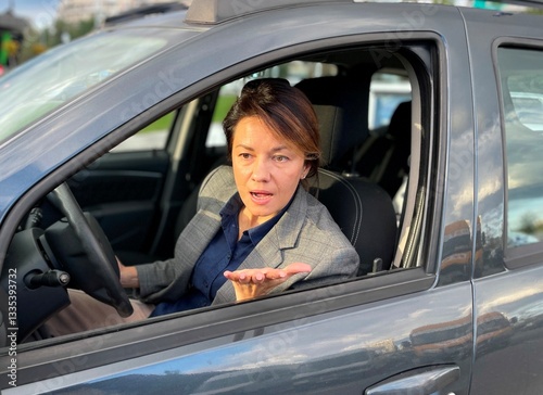 Close up of Caucasian pretty woman sitting in auto looking through window with pretentious face expression. Traffic. Woman driver unhappy with road trip. Trip concept