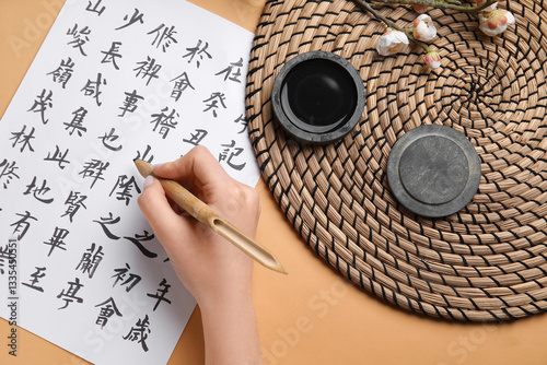 Woman writing Asian hierogl...