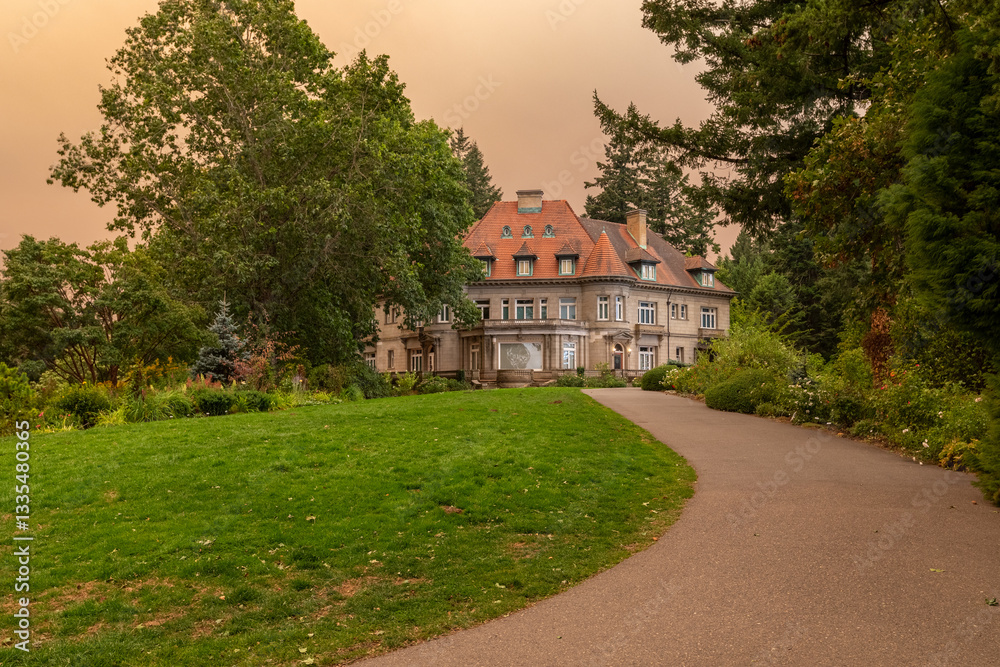 Fototapeta premium Pittock Mansion in Portland, Oregon, under an orange-tinted sky caused by thick wildfire smoke from the devastating 2020 fires, highlighting environmental disaster effects