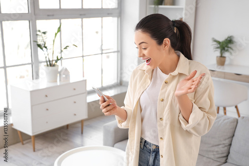 Surprised young woman using...