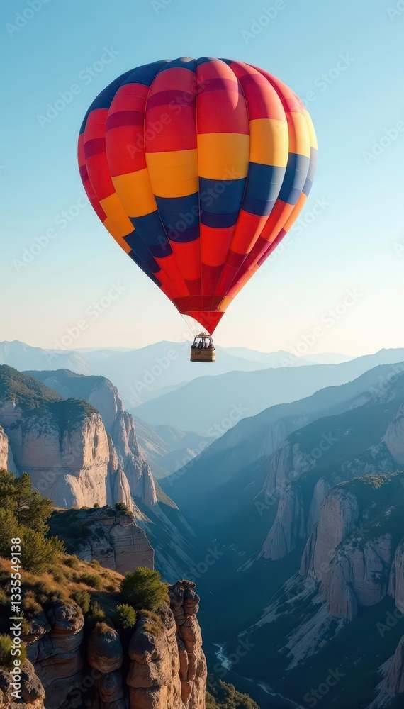 Obraz premium Colorful balloon floats above dramatic mountain range , mountains, hot air balloon, clouds