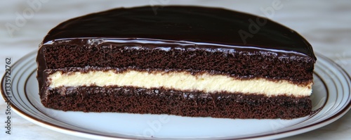 A delectable chocolate cake with a creamy filling, elegantly presented on a plate, showcasing its rich layers and glossy ganache.