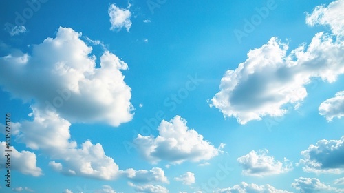 Blue Sky With Fluffy Clouds: A serene blue sky is adorned with fluffy white clouds that seem to drift lazily in the gentle breeze. The image captures the beauty and peacefulness of a clear day. 