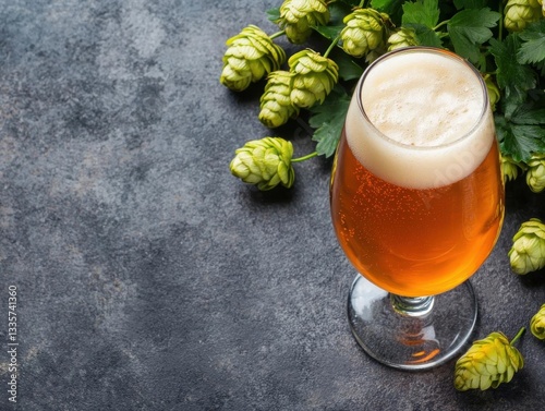 craft beer homebrewing fermentation. Golden craft beer in a tulip glass next to a homebrewing journal and fresh hop cones
