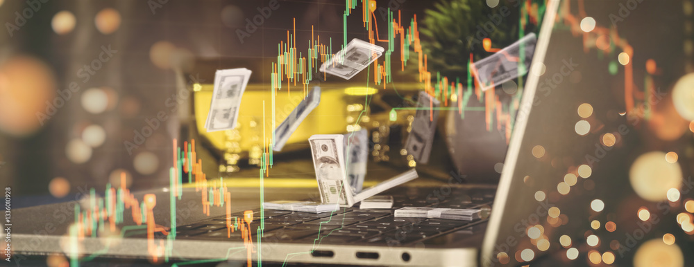 Workspace for investment and profit in financial market with scattered money, candlestick chart on laptop, gold bars,