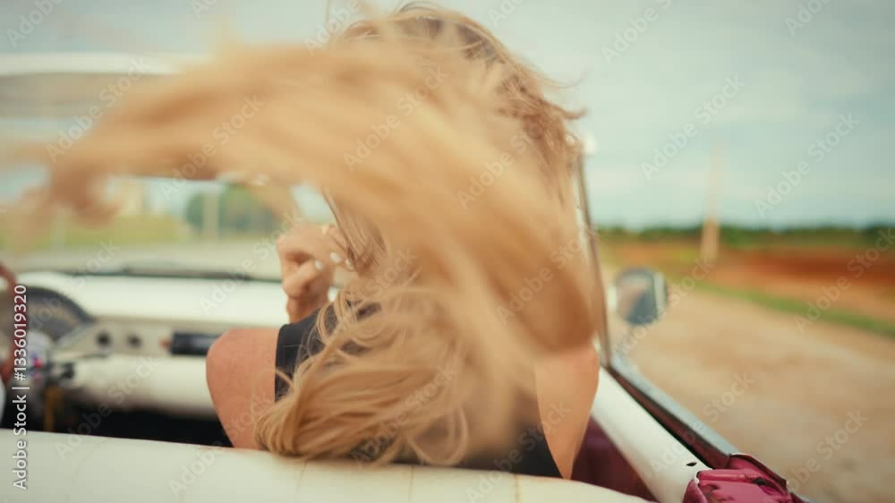 High speed and freedom, woman riding cabriolet auto in summer day, back view. Beautiful blonde lady enjoying life and wind, move fast on car road, rearview, female passenger admiring views around