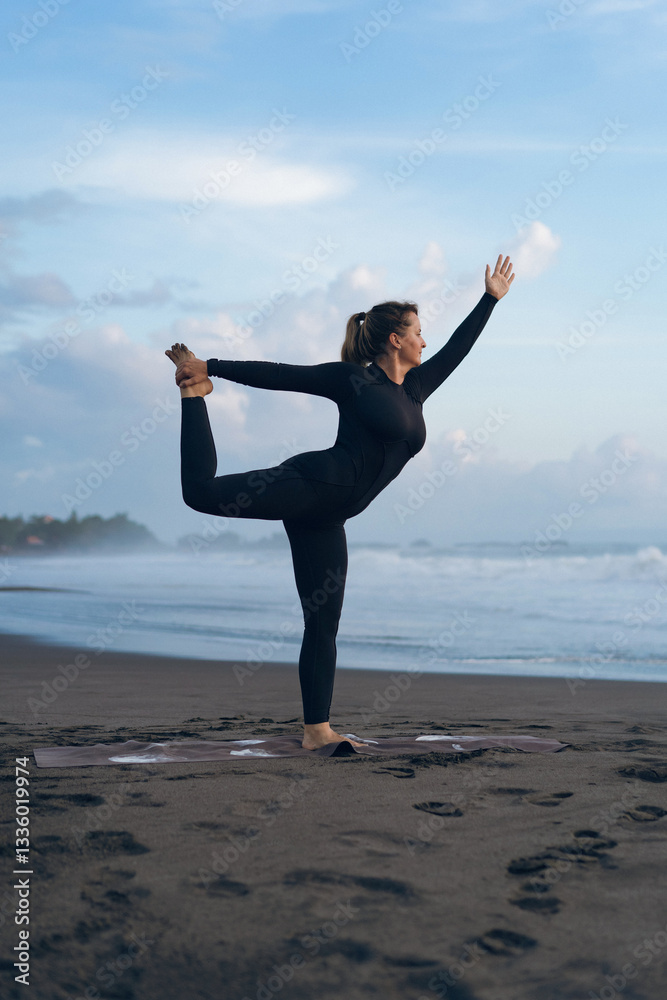 Woman practicing yoga at beach against clear sky during sunset Woman practicing yoga at beach against clear sky during sunset
